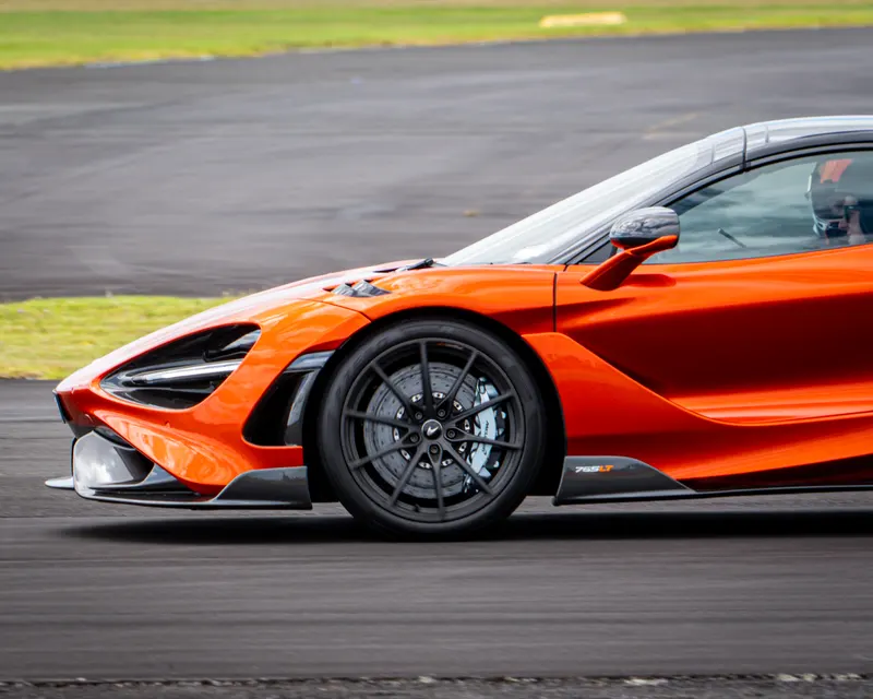 Orange McLaren photographed in motion from a low side angle