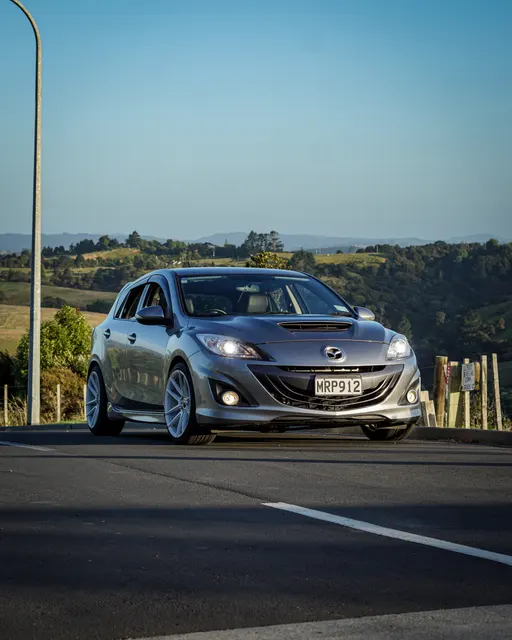 Grey performance car photographed from the front on an open road