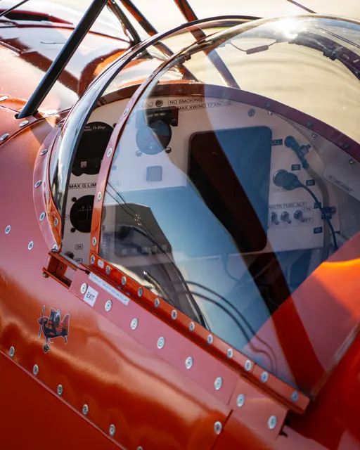 Close detail of the canopy and cockpit of an orange aircraft
