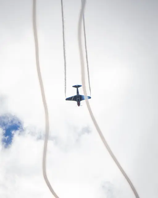 Aerobatic aircraft flying between curved smoke trails