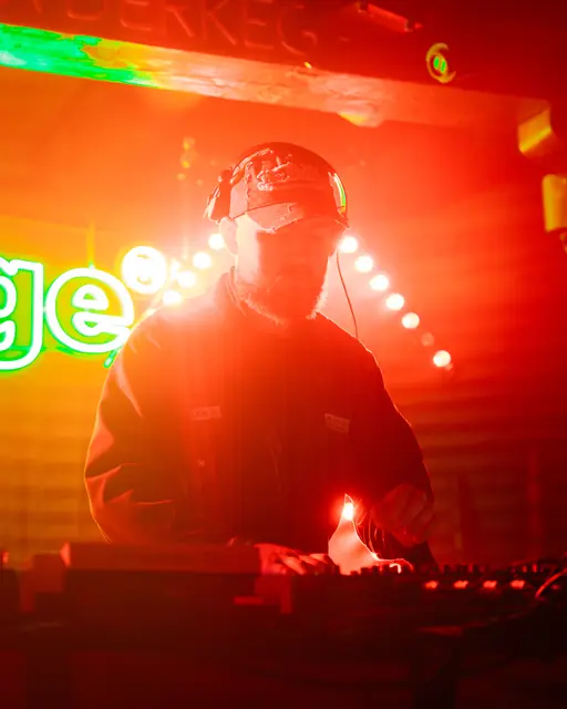 DJ silhouetted by red and green stage lighting